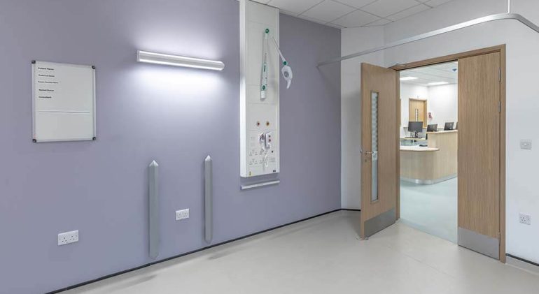 A view inside a modular ward with light purple walls and beige floors, and a white tile roof.